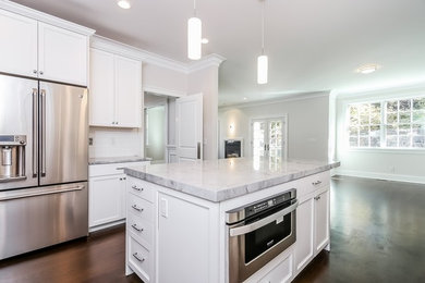 Eat-in kitchen - large contemporary l-shaped dark wood floor eat-in kitchen idea in New York with shaker cabinets, dark wood cabinets, white backsplash, subway tile backsplash, stainless steel appliances, an island, an undermount sink and quartzite countertops