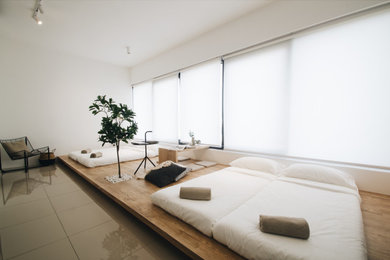 Modelo de dormitorio de estilo zen pequeño con paredes blancas, suelo de baldosas de cerámica y suelo beige