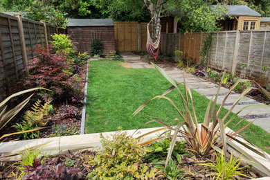 Photo of a medium sized contemporary back partial sun garden with a garden path and decking.
