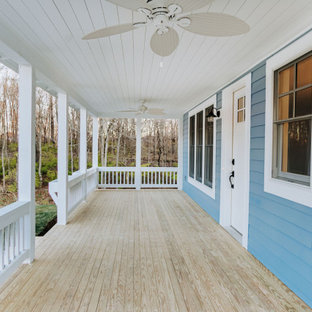 Ispirazione per un ampio portico stile americano davanti casa con pedane, un tetto a sbalzo e parapetto in legno