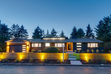 Modelo de fachada de casa gris y negra retro grande de dos plantas con revestimientos combinados, tejado a dos aguas, tejado de teja de madera y tablilla