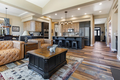 Example of a large mountain style l-shaped medium tone wood floor and multicolored floor open concept kitchen design in Denver with shaker cabinets, light wood cabinets, granite countertops and an island