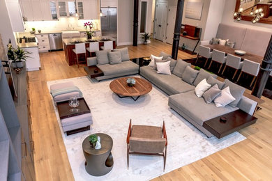 Inspiration for an expansive contemporary loft-style family room in New York with white walls, light hardwood floors, no fireplace, a built-in media wall and beige floor.