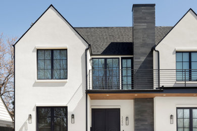 Inspiration for a large eclectic white two-story stucco house exterior remodel in Denver with a black roof