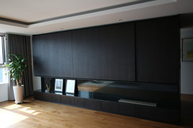 Large minimalist open concept medium tone wood floor living room photo in Other with white walls, a standard fireplace, a stone fireplace and a concealed tv