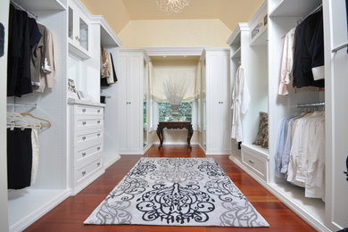 Mid-sized transitional gender-neutral medium tone wood floor walk-in closet photo in Newark with recessed-panel cabinets and white cabinets