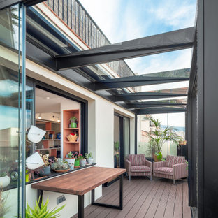 Modelo de terraza actual, de tamaño medio, en azotea, con chimenea, pérgola y barandilla de metal