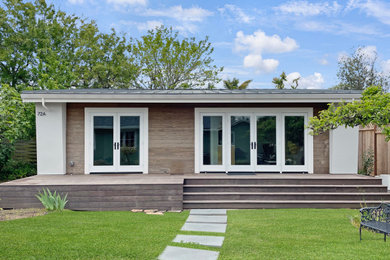 Example of a small trendy gray one-story stucco tiny house design with a shed roof, a metal roof and a gray roof