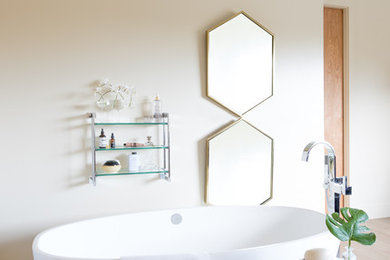 Inspiration for a large master light wood floor and beige floor freestanding bathtub remodel in Denver with beige walls