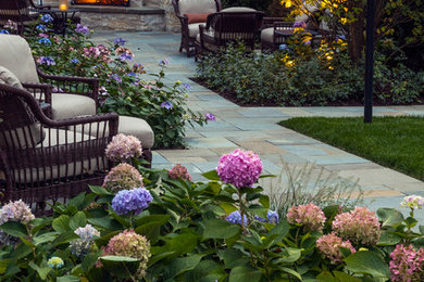 Design ideas for a large traditional partial sun backyard stone formal garden in Chicago with a fireplace.