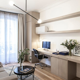 Inspiration för ett skandinaviskt hemmabibliotek, med vita väggar, ljust trägolv och ett inbyggt skrivbord