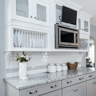 Mid-sized traditional kitchen pantry designs - Inspiration for a mid-sized timeless u-shaped medium tone wood floor kitchen pantry remodel in Providence with a farmhouse sink, shaker cabinets, gray cabinets, granite countertops, white backsplash, subway tile backsplash and stainless steel appliances