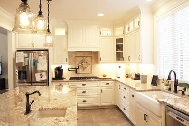 Large elegant u-shaped porcelain tile and beige floor enclosed kitchen photo in Atlanta with a farmhouse sink, raised-panel cabinets, white cabinets, quartzite countertops, beige backsplash, stone tile backsplash, stainless steel appliances, an island and gray countertops