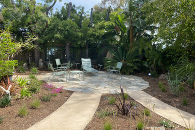 Design ideas for a small eclectic drought-tolerant and partial sun backyard stone flower bed in San Diego.