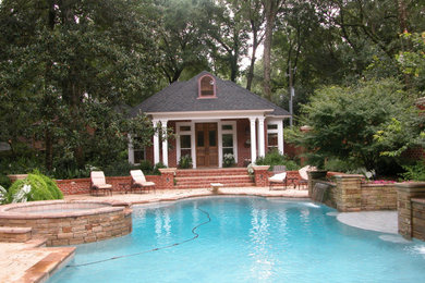 Modelo de piscinas y jacuzzis naturales clásicos extra grandes en patio trasero con suelo de hormigón estampado
