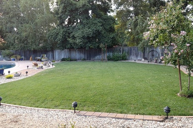 Foto de jardín tradicional de tamaño medio en patio trasero con muro de contención y mantillo