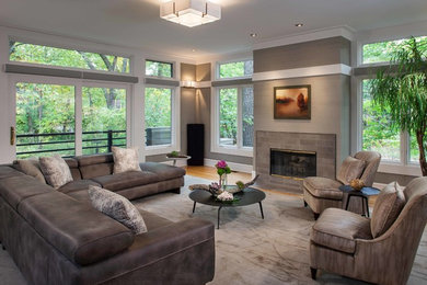 Family room - mid-sized transitional light wood floor family room idea in Chicago with gray walls, a standard fireplace, a tile fireplace and no tv