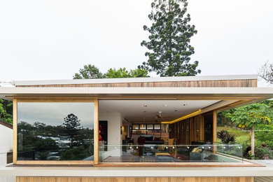 Imagen de fachada de casa marrón contemporánea de tamaño medio a niveles con revestimiento de madera, tejado de un solo tendido y tejado de metal