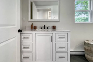 Mid-sized beach style single-sink bathroom photo in Boston with white cabinets, marble countertops and white countertops