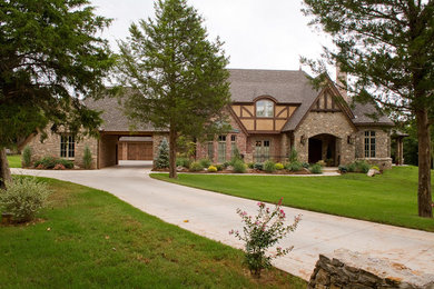Large traditional gray two-story stone exterior home idea in Oklahoma City with a shingle roof