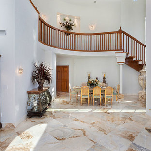 Idées déco pour un très grand hall d'entrée éclectique avec un mur blanc, un sol en marbre, une porte double, une porte en bois brun et un sol multicolore.
