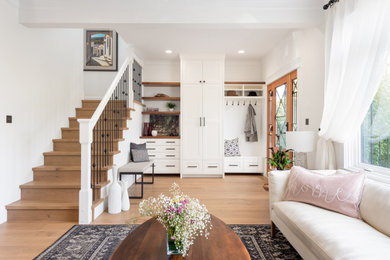 Inspiration for a mid-sized transitional front door in Vancouver with white walls, light hardwood floors, a single front door, a brown front door and brown floor.