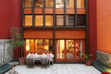 Immagine di un grande patio o portico minimal dietro casa con un giardino in vaso, piastrelle e nessuna copertura