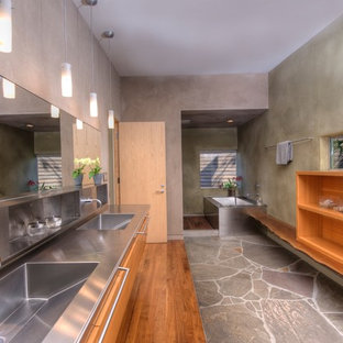 Ispirazione per una stanza da bagno minimalista con lavabo integrato, nessun'anta, ante in legno scuro, top in acciaio inossidabile, pareti grigie e vasca sottopiano