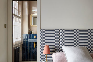 Medium sized modern master bedroom in London with beige walls, painted wood flooring, black floors and a dado rail.