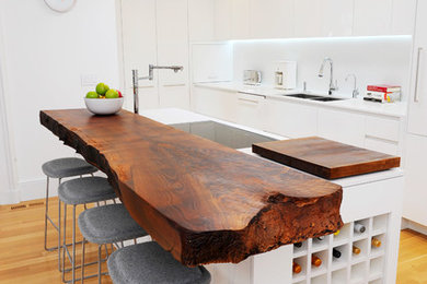 Kitchen - eclectic u-shaped kitchen idea in San Francisco with a double-bowl sink, flat-panel cabinets, white cabinets, wood countertops and white countertops