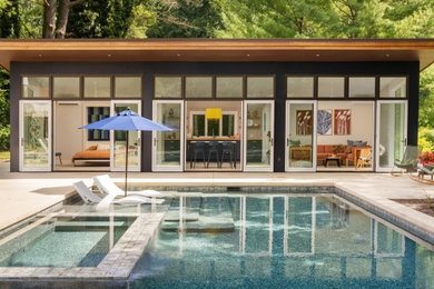 Example of a large mid-century modern backyard rectangular pool house design in Wilmington