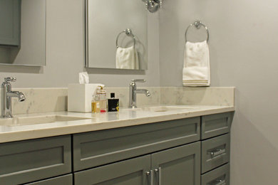 This is an example of a small traditional kids bathroom in Boston with recessed-panel cabinets, grey cabinets, an alcove shower, a two-piece toilet, gray tile, porcelain tile, grey walls, porcelain floors, an undermount sink, engineered quartz benchtops, grey floor, a hinged shower door and white benchtops.