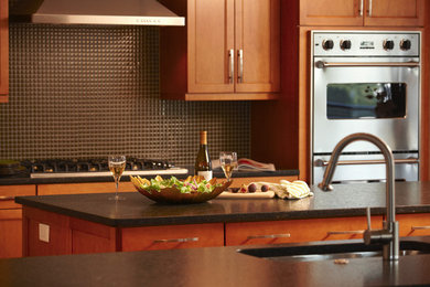 Inspiration for a large contemporary kitchen remodel in Chicago with a double-bowl sink, shaker cabinets, medium tone wood cabinets, granite countertops, brown backsplash, mosaic tile backsplash, stainless steel appliances and an island