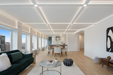 Example of a huge trendy open concept light wood floor, beige floor and coffered ceiling living room design with white walls, no fireplace and a wall-mounted tv