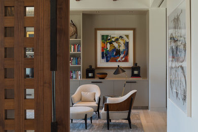 Large contemporary home office in Austin with white walls, light hardwood floors and beige floor.