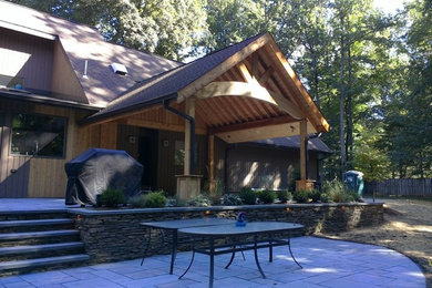 Ejemplo de patio rústico grande en patio trasero y anexo de casas con adoquines de piedra natural