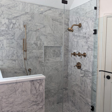 Modern primary bathroom with marble tile, curbless shower and custom vanity