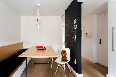 Photo of a mid-sized scandinavian separate dining room in New York with white walls and light hardwood floors.