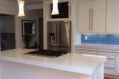 Trendy light wood floor kitchen photo in Denver with shaker cabinets, white cabinets, subway tile backsplash, stainless steel appliances, an island and quartz countertops