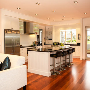 Transitional kitchen pantry ideas - Kitchen pantry - transitional medium tone wood floor kitchen pantry idea in Hamilton with a double-bowl sink, white cabinets, granite countertops, white backsplash, stainless steel appliances and an island