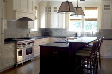 Example of a large trendy l-shaped light wood floor and beige floor open concept kitchen design in Boston with an undermount sink, recessed-panel cabinets, white cabinets, gray backsplash, matchstick tile backsplash, stainless steel appliances and an island