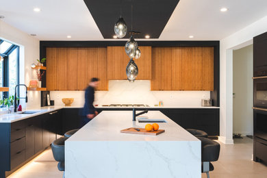 Photo of a contemporary u-shaped eat-in kitchen in DC Metro with flat-panel cabinets, black cabinets, quartz benchtops, white splashback, engineered quartz splashback, porcelain floors, with island, beige floor and white benchtop.