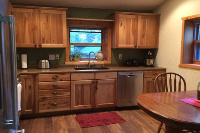 Eat-in kitchen - mid-sized traditional l-shaped medium tone wood floor eat-in kitchen idea in Other with an undermount sink, flat-panel cabinets, medium tone wood cabinets, laminate countertops and stainless steel appliances
