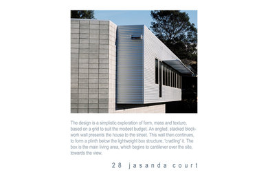 Cette image montre une petite façade de maison grise design en béton de plain-pied.