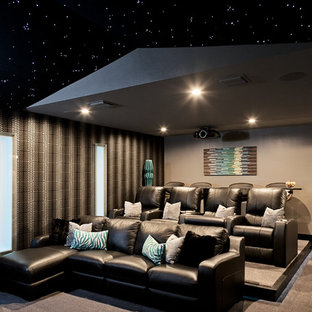 Inspiration for a large contemporary enclosed carpeted and beige floor home theater remodel in Orlando with a projector screen and gray walls