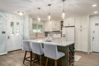 Example of a mid-sized transitional l-shaped vinyl floor eat-in kitchen design in Columbus with quartz countertops, subway tile backsplash and an island