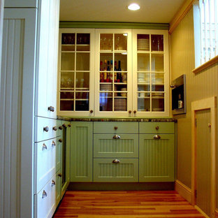 Small beach style kitchen pantry ideas - Small coastal l-shaped medium tone wood floor kitchen pantry photo in Portland Maine with glass-front cabinets, white cabinets, laminate countertops and paneled appliances