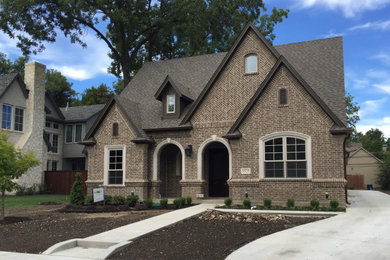 Large french country brown two-story brick house exterior idea in Dallas with a shingle roof and a gray roof