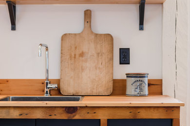 Photo of a scandinavian kitchen in New York with wood benchtops.