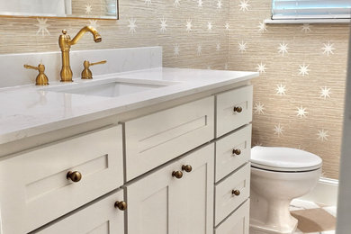 Example of a mid-sized transitional kids' porcelain tile, white floor, single-sink and wallpaper bathroom design in Dallas with shaker cabinets, beige cabinets, a two-piece toilet, beige walls, an undermount sink, quartz countertops, white countertops and a freestanding vanity